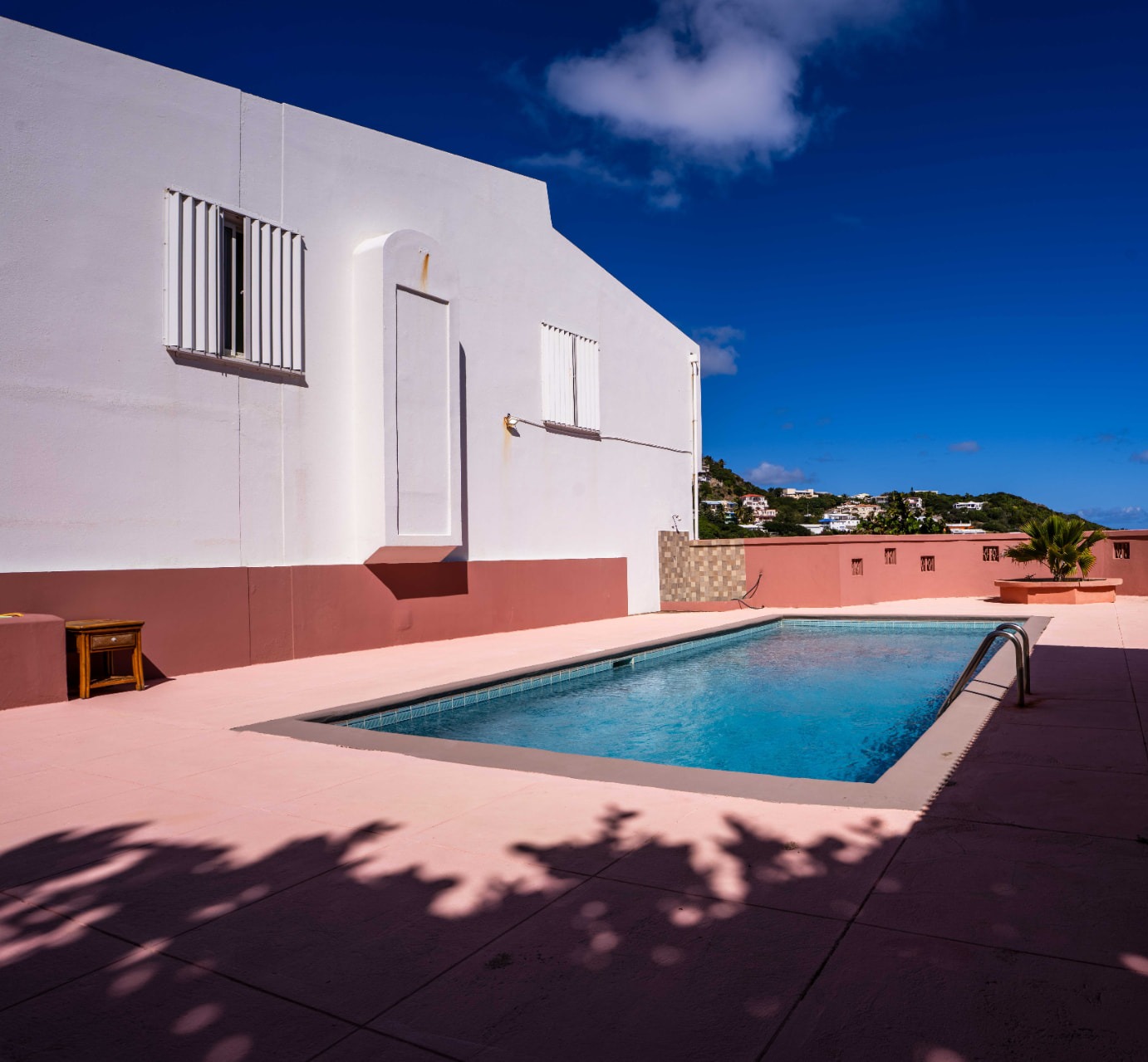 Sunlit pool deck with island views