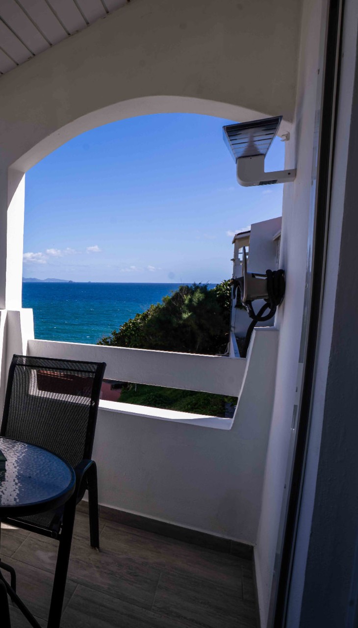 Arched balcony with bistro table looking out to the sea