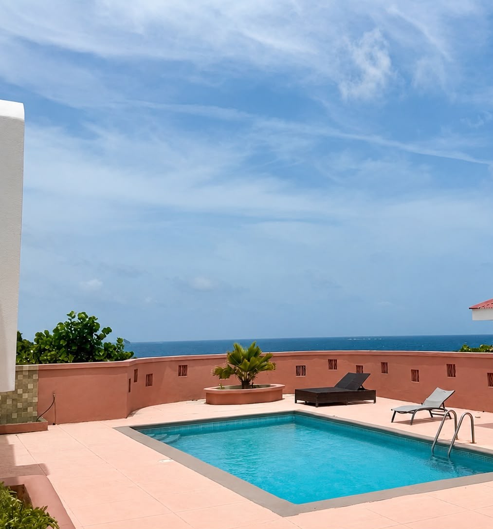Pool and loungers with the open sea beyond