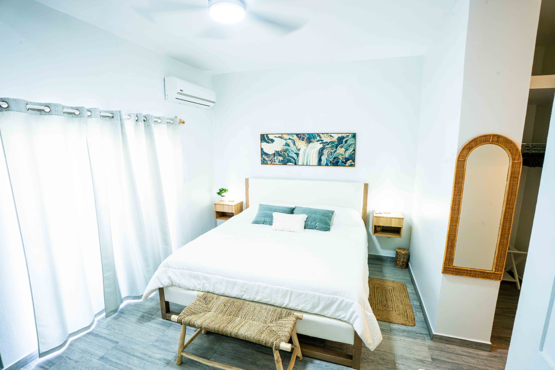 Bedroom with rattan mirror and open closet