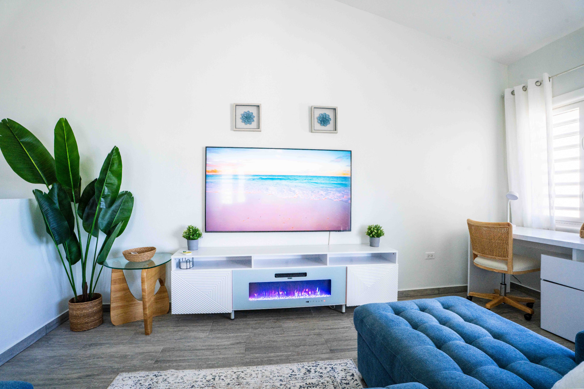 Living room with faux fireplace, greenery and workspace