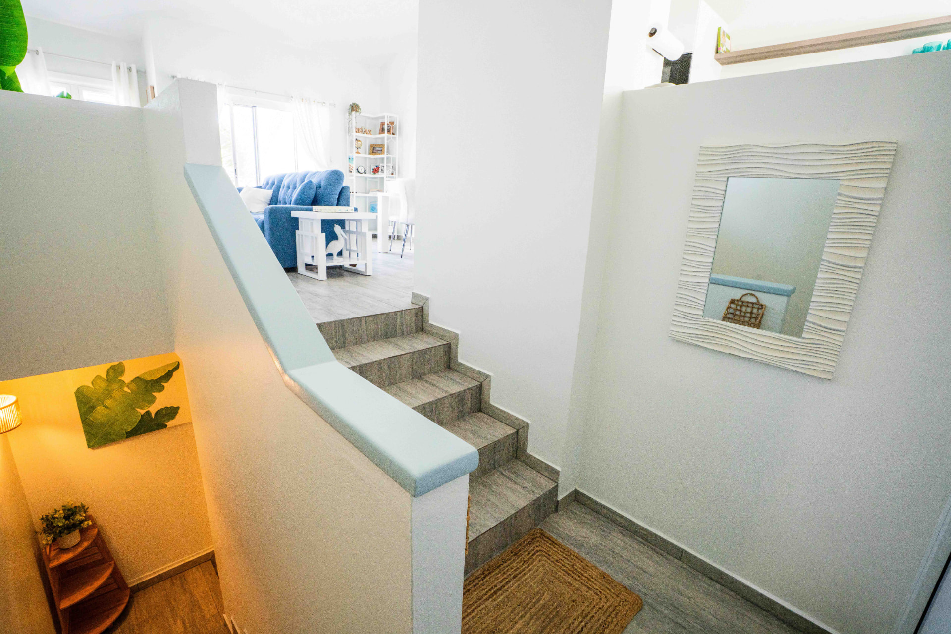 Entry hall with coastal mirror and stairs up to the living area