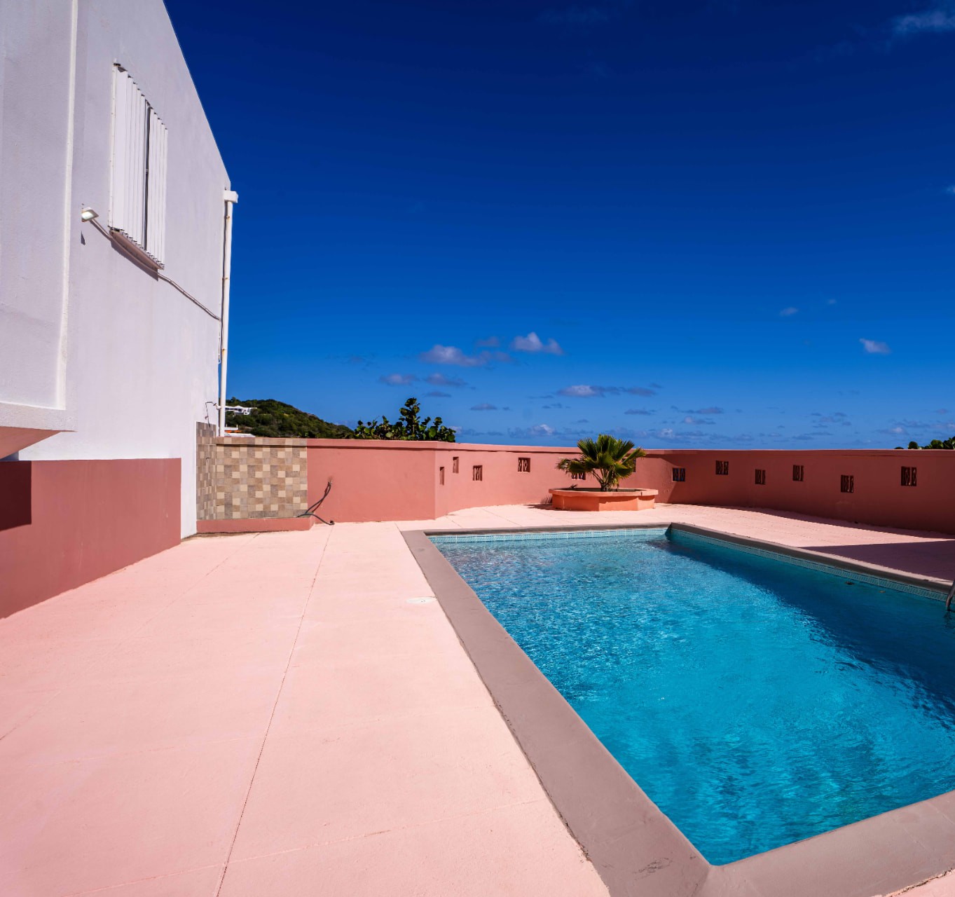 Shared pool with clear blue water and a wide sun terrace