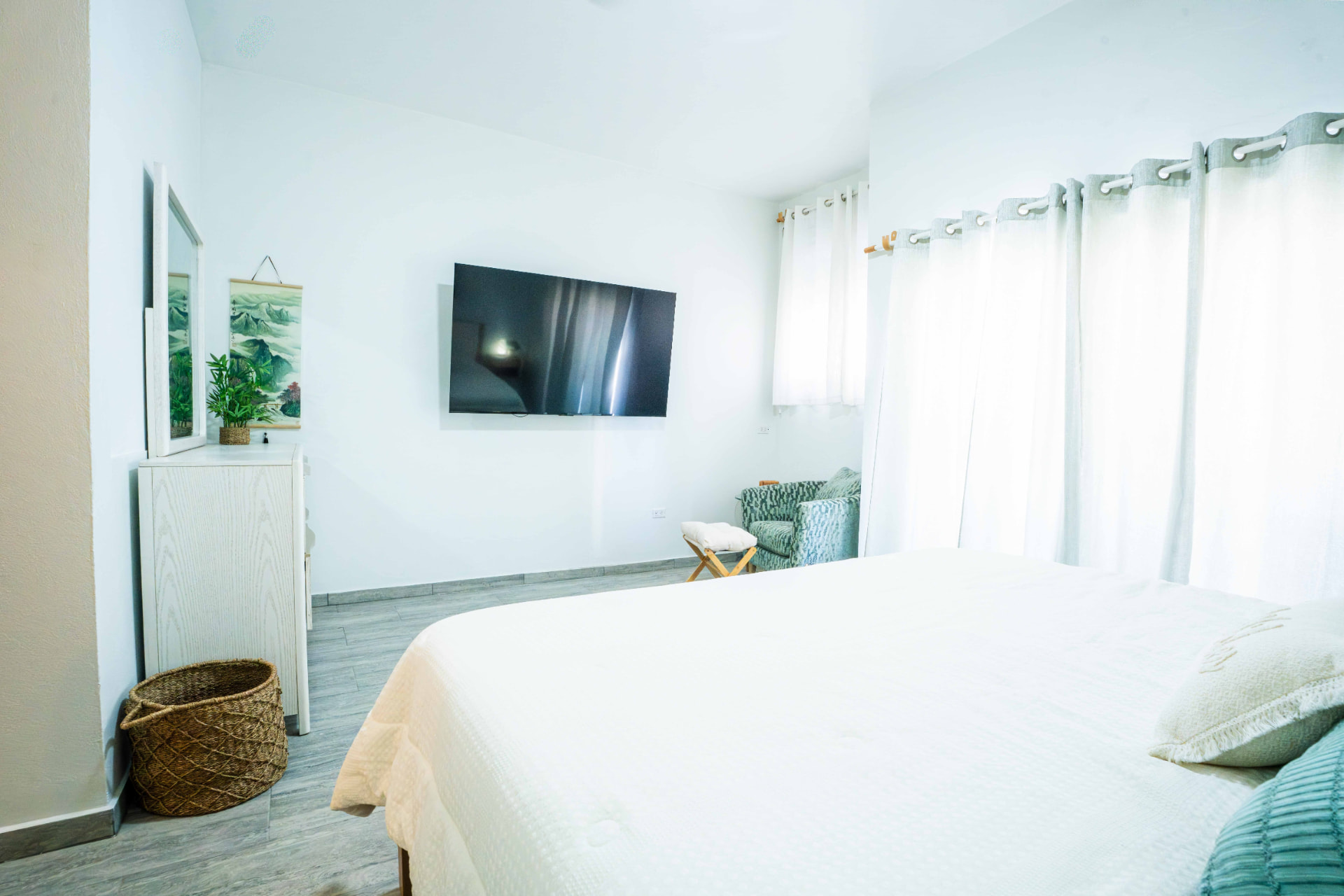 Bedroom with wall mounted TV and seating corner